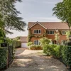 Charming brick house with ivy, surrounded by trees, on a sunny day in the English countryside