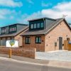 Modern brick homes with slate roofs and driveways in a residential neighbourhood under a clear blue sky