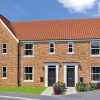 Modern semi-detached brick house with red roof and tidy garden in a UK neighbourhood under blue sky