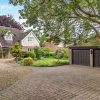 Charming English countryside home with lush garden and spacious driveway, featuring a classic pitched roof and garage