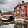 Charming red brick buildings by a tranquil river with a bridge in a picturesque UK townscape