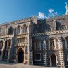 Historic gothic-style building with stone facade under a clear blue sky in the UK