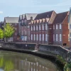 Charming riverside scene of colourful traditional houses and lush green trees along a tranquil waterway in the UK
