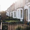 Row of traditional British terraced houses with gardens and sunset lighting