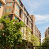 Modern apartment buildings with trees and clear blue sky in an urban setting