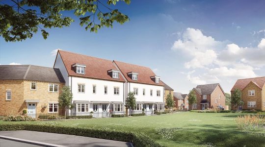 Modern UK housing development with terraced and detached houses in a green residential area under a blue sky