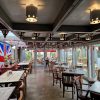 UK-themed cafe interior with Union Jack decor, wooden tables, and outdoor garden view through glass windows