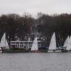 Sailing boats docked by a tree-lined shore on a cloudy day at a scenic lake in the UK