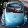 Vintage blue microcar in a garage, showcasing retro design and compact dimensions for classic car enthusiasts