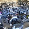 Collection of vintage motorcycles displayed in a garage with classic models from different eras