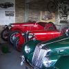 Vintage MG cars in a garage display showcasing classic automotive history with vibrant red and green colours