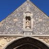 Close-up of a historic church facade with detailed stone carvings under a clear blue sky in the UK
