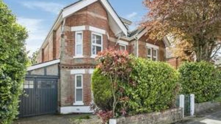 Charming Victorian-style red brick house with garage and lush garden in peaceful suburban neighbourhood