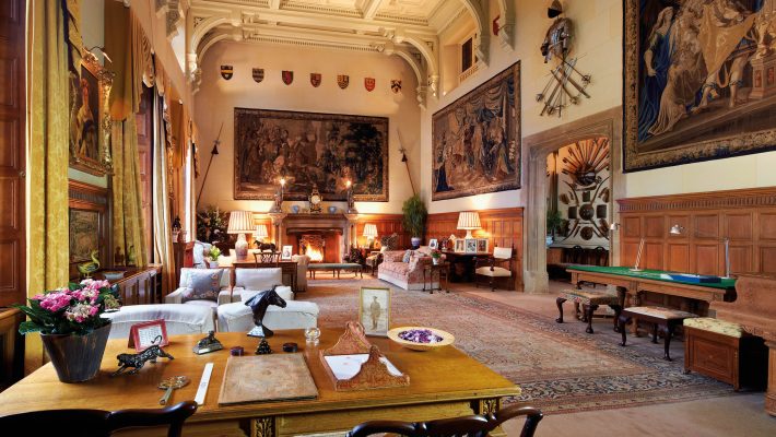 Luxurious historic living room with elegant decor, tapestries, and ornate ceiling in traditional English manor house