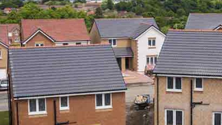 Aerial view of new residential homes in a suburban UK neighbourhood with modern architecture and landscaped gardens