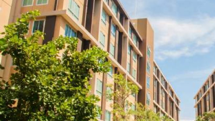 Modern apartment buildings with trees and clear blue sky in an urban setting